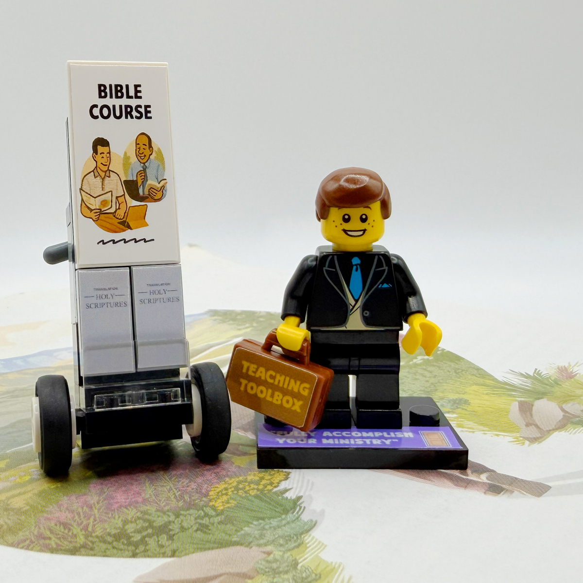 Brick figure with a Bible Course book and teaching toolbox on a map background