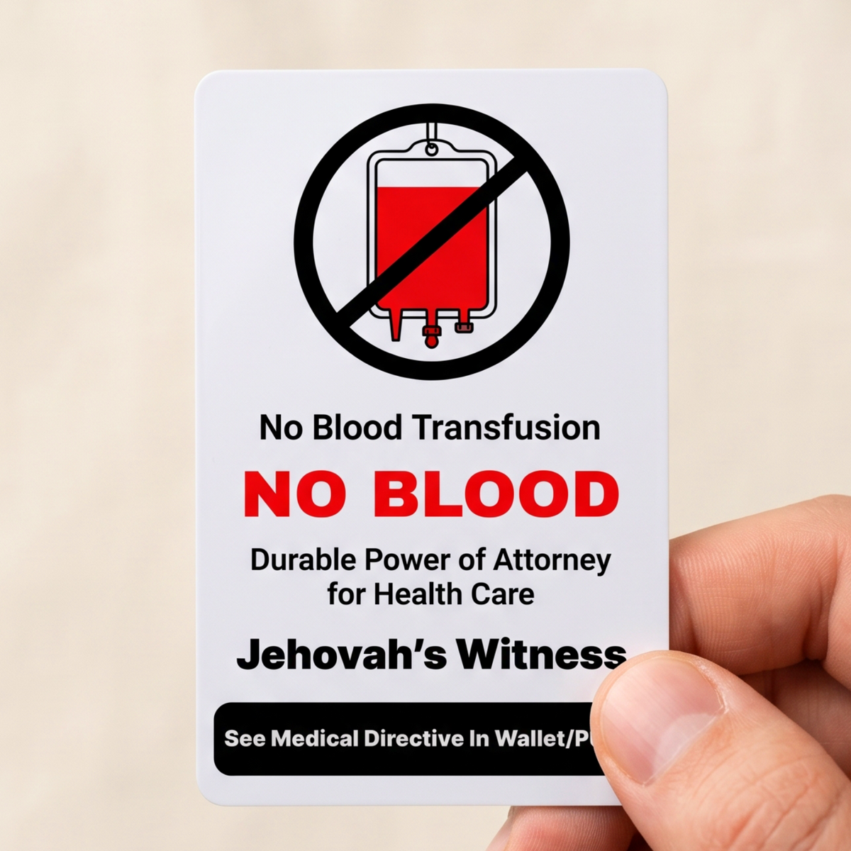 A hand holding a white rectangular medical directive card that reads 'No Blood Transfusion', 'NO BLOOD', and 'Jehovah’s Witness' with a red-and-black crossed-out blood bag icon, against a soft beige fabric background.