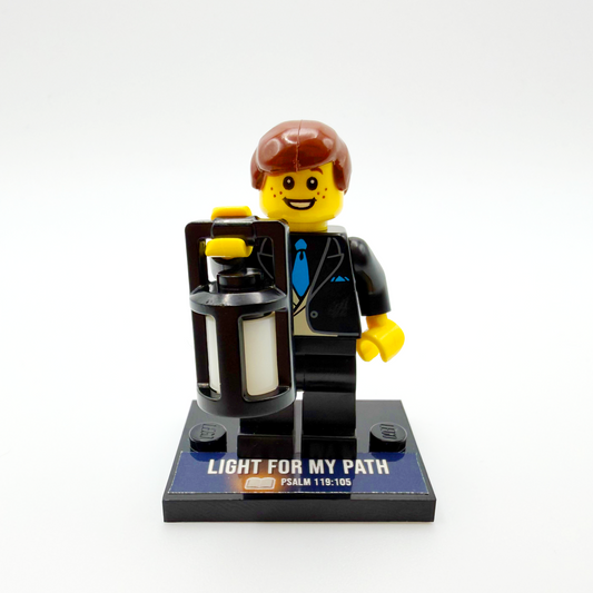 Brick figure with a suitcase and 'Light for My Path' text on a white background