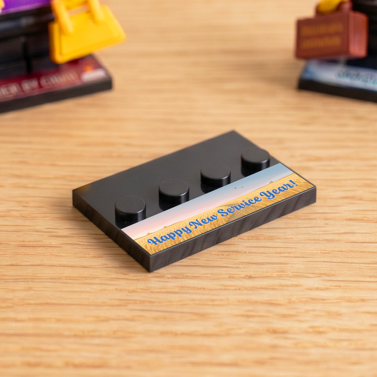 Black brick figure display stand with a 'Happy New Service Year!' decal
