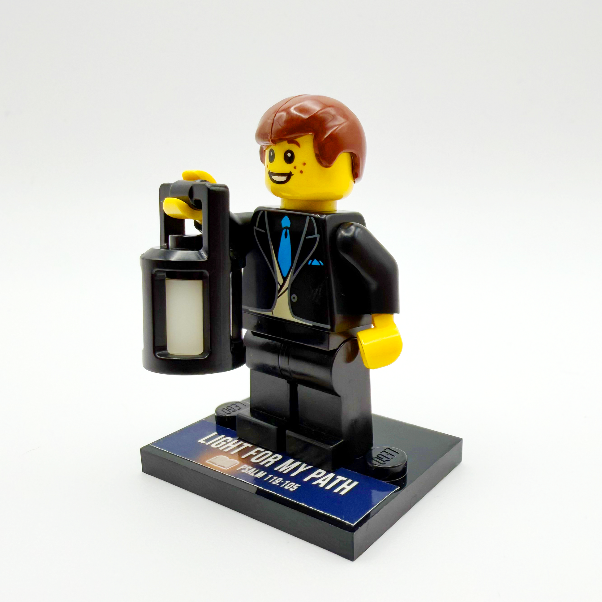 Brick figure of a businessman holding a lantern on a white background
