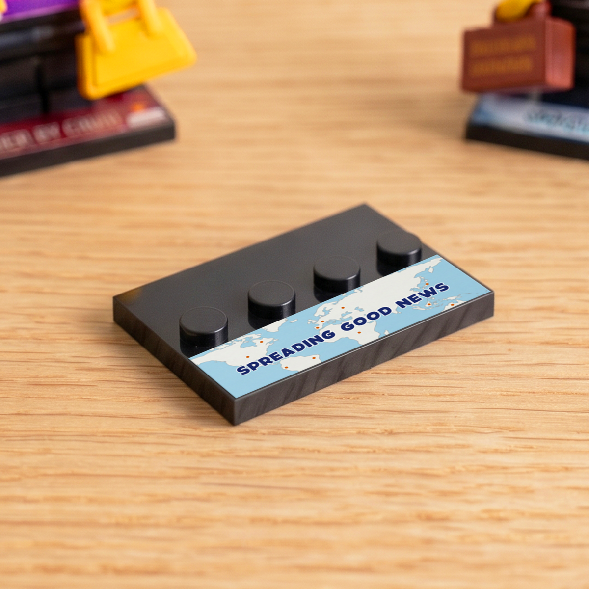 Black brick figure display stand with a 'Spreading Good News' decal
